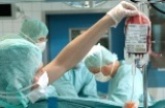 Foto: Portrait einer Blutspenderin - im Hintergrund eine Blutspende.